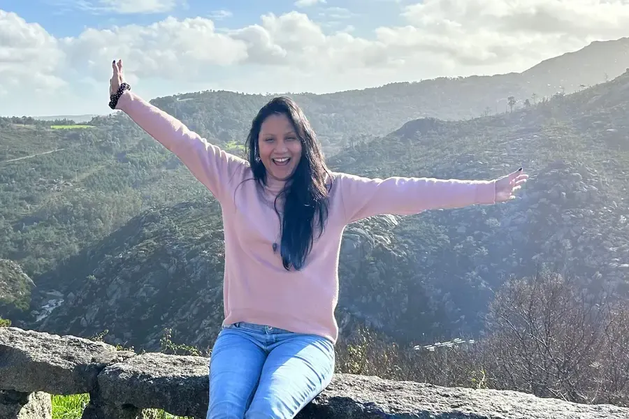 Maryana Morgado, creadora de Renace, con los brazos abiertos en lo alto de una montaña.